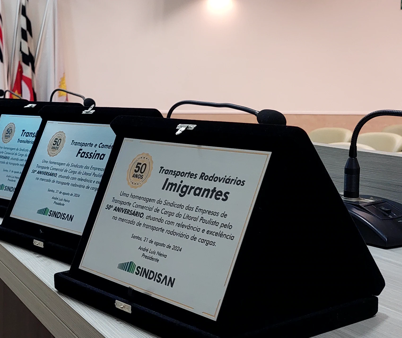 Placa comemorativa dos 50 anos da Transportes Rodoviários Imigrantes, entregue pelo SINDISAN, ao lado das placas de outras transportadoras homenageadas